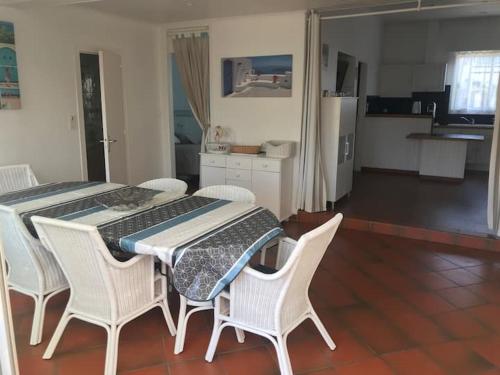 Il dispose d'une cuisine et d'une table à manger avec des chaises blanches. dans l'établissement MAMALO, à Biscarrosse
