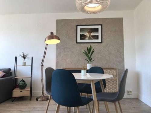 a dining room with a table and blue chairs at Appartement - 45m2 avec parking in Avon