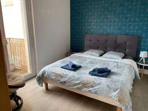 a bedroom with a bed with two blue towels on it at Appartement - 45m2 avec parking in Avon