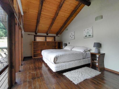 a bedroom with a bed and a wooden ceiling at Tumuñan Lodge in El Llano