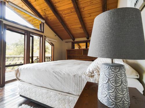 a bedroom with a bed and a lamp on a table at Tumuñan Lodge in El Llano