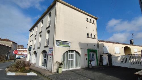 un grand bâtiment blanc sur le côté d'une rue dans l'établissement Résidence L'Ogomé, à Le Boupère