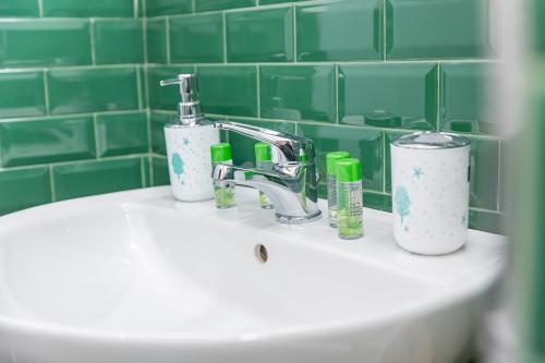 a bathroom sink with a faucet and two cups on it at CENTRO STORICO Redmood House a 5 min dal Mare, Aria Condizionata, Wi-Fi e Netflix in Barletta