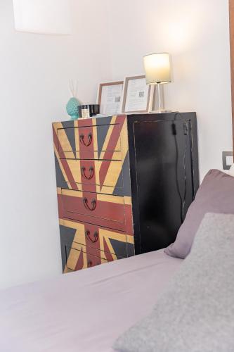 a bedroom with a bed and a dresser with a lamp at CENTRO STORICO Redmood House a 5 min dal Mare, Aria Condizionata, Wi-Fi e Netflix in Barletta