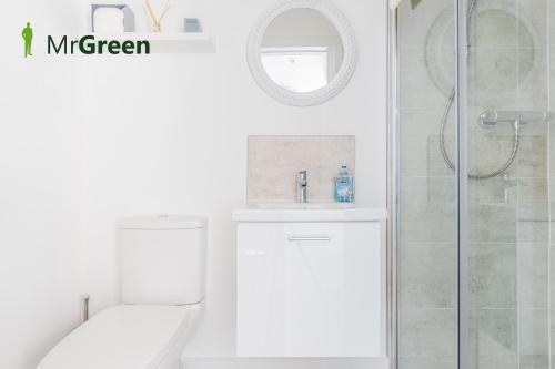 uma casa de banho branca com um WC e um chuveiro em Wick Studio em Christchurch