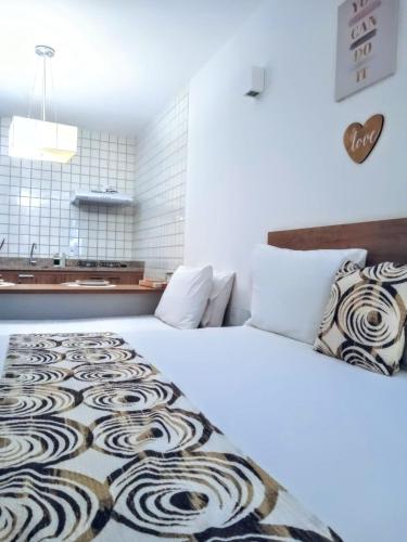 a bedroom with a large white bed with a rug on it at Mar Turquesa Eco Pousada in Maragogi