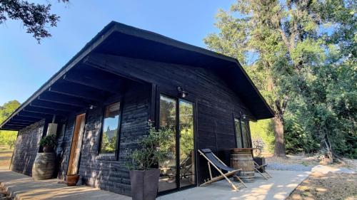 una pequeña casa negra con una gran ventana en Tumuñan Lodge, en El Llano