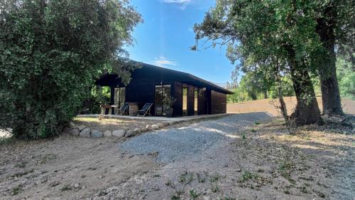a small cabin with a black roof in a field at Tumuñan Lodge in El Llano