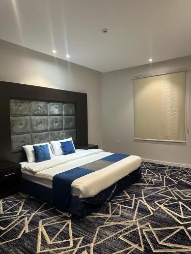 um quarto com uma cama grande e almofadas azuis em الريف بلس em Hajlah