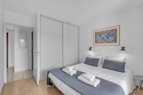 une chambre avec un grand lit avec deux oreillers dessus dans l'établissement T2 Bord de Garonne hypercentre terrasse + Parking, à Toulouse