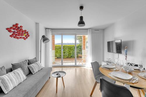 - un salon avec un canapé et une table à manger dans l'établissement T2 Bord de Garonne hypercentre terrasse + Parking, à Toulouse