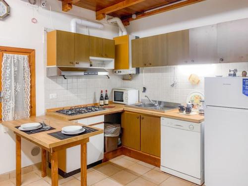 una cucina con armadi in legno e frigorifero bianco di CASA BIVO by Design Studio a Pontelongo