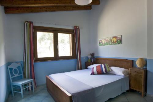 Un dormitorio con una cama y una ventana y una silla. en Villa Michela tra Cielo e Mare, en Gaeta