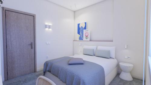 een witte slaapkamer met een bed met een blauwe deken bij StayBridge Apartments, Mesongi in Mesongi