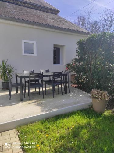 un patio con tavolo e sedie di fronte a una casa di L'escapade a Julos