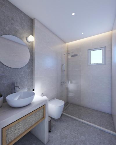 een badkamer met een wastafel, een toilet en een spiegel bij StayBridge Apartments, Mesongi in Mesongi