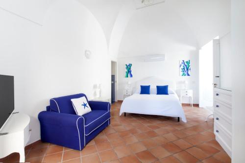 - une chambre avec un lit et une chaise bleue dans l'établissement Casa Mimosa, à Positano