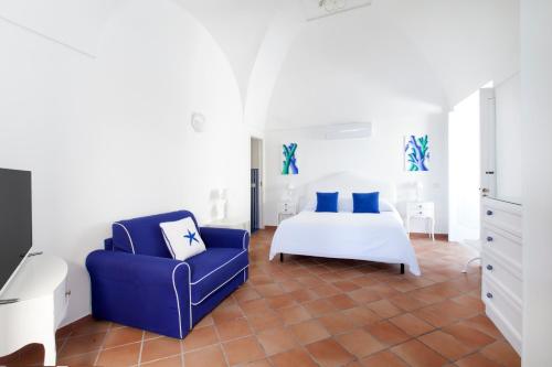sypialnia z łóżkiem i niebieskim krzesłem w obiekcie Casa Mimosa w mieście Positano