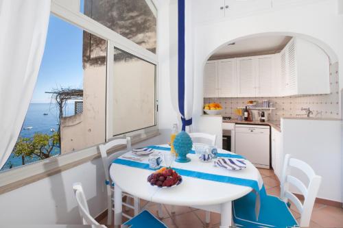 a kitchen with a table and a large window at Casa Mimosa in Positano