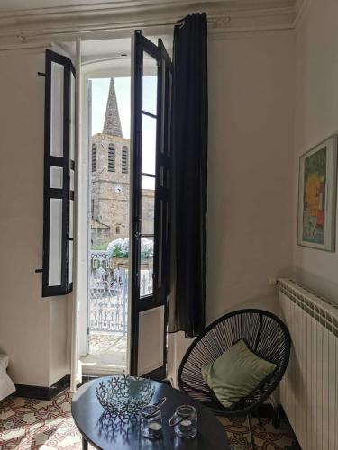 une pièce avec une table, une chaise et une fenêtre dans l'établissement Maison de village avec sa charmante grand chambre avec balcon, à Fleury