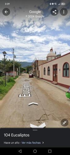 an empty road with a car parked on the side at T in San Agustin de las Juntas