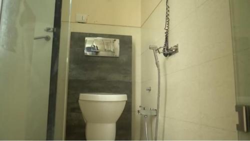 a bathroom with a white toilet and a shower at Rao Regency in Gurgaon