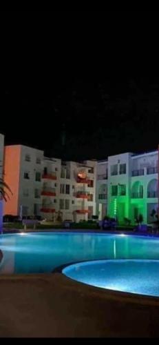 uma piscina em frente a um edifício à noite em Apparemment grand standing pied dans l'eau em Douane