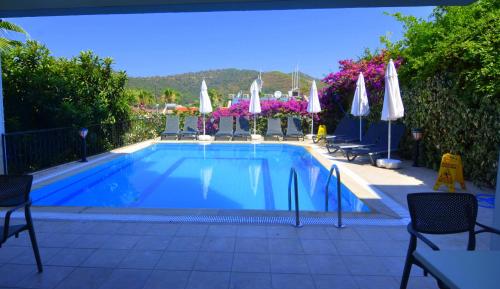 a swimming pool with chairs and umbrellas on a patio at Mykonut Boutique Suites in Fethiye