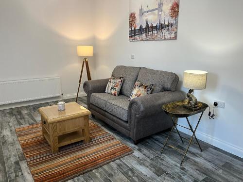 a living room with a couch and a table at Millbrae Lodges in Belfast