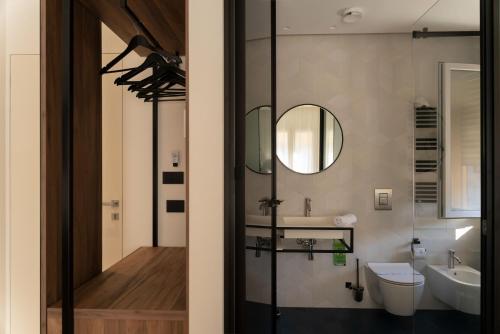 un bagno con lavandino, WC e specchio di Suites di Costanza a Cefalù