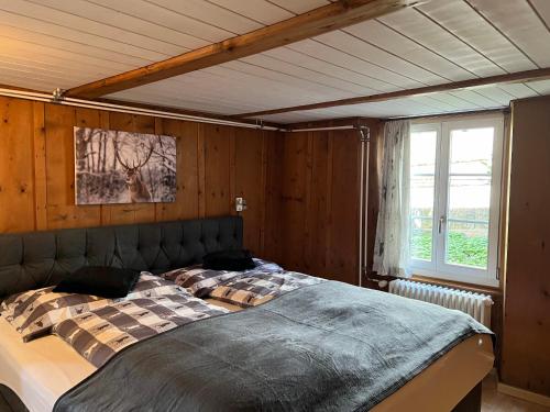 Cama grande en habitación con paredes de madera en Apartment Deer, en Grindelwald