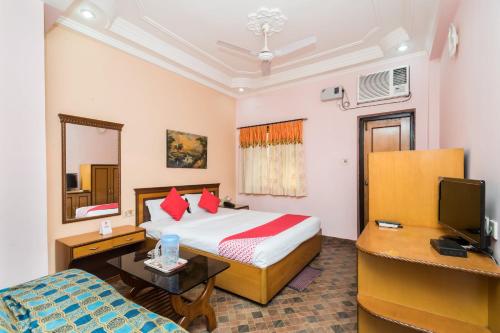 a hotel room with a bed and a television at Capital O Bidisha in Digha