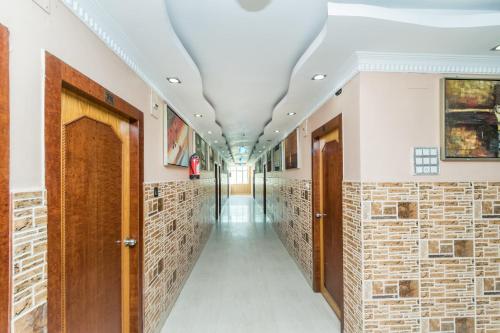 un couloir avec des murs en briques et des portes en bois dans l'établissement Super Capital O Hotel Bidisha, à Digha