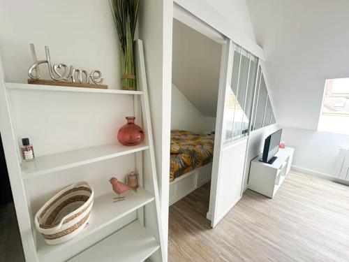 a room with a mirror and a bedroom with a bed at Charmant studio proche de la gare in Rambouillet