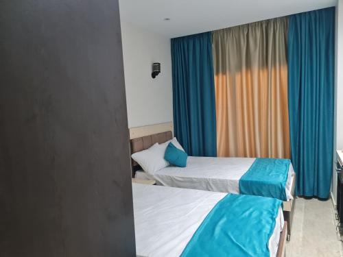 duas camas num quarto com cortinas azuis em ميراج باي (شاليه) em Hurghada