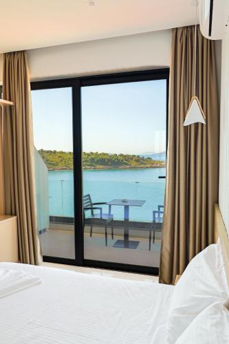 a bedroom with a bed and a view of the ocean at Villa Xhefri 2 in Sarandë