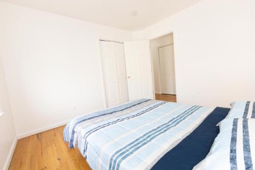 1 dormitorio con 1 cama con manta de rayas azul y blanco en Elegant 3Bedroom Apt Close to NYC en Jersey City