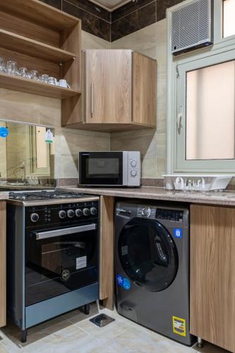 a kitchen with a black dishwasher and a microwave at El Lotus Building in Cairo
