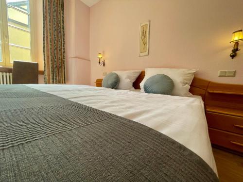 a bedroom with a large bed with two pillows at Hotel Schloss Zell in Zell an der Mosel