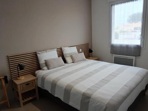 コロンビエールにあるColombiers Escale à la Noria Appartement terrasse 4 personnes et garageの大きなベッドと窓のある寝室