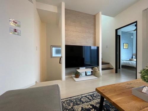 a living room with a large flat screen tv at Casa YONNA Miyakojima in Miyako-jima