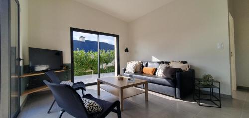 uma sala de estar com um sofá e uma mesa em Maison d'hôtes Proche du port de la Roche-Bernard. em Férel