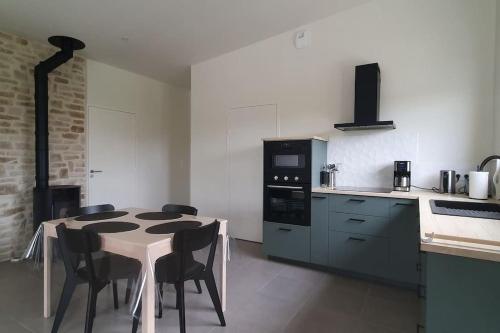 une cuisine avec une table et des chaises dans une cuisine dans l'établissement Maison d'hôtes Proche du port de la Roche-Bernard., à Férel