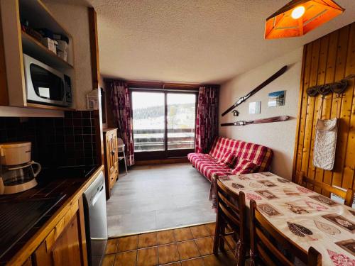 - une cuisine avec un canapé et une table dans une chambre dans l'établissement Studio cabine cosy aux Saisies, sud, 4 pers, skis aux pieds, proche ESF, tout équipé - FR-1-293-169, aux Saisies