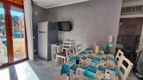 een keuken met een tafel met stoelen en een koelkast bij Completely refurbished flat near the beach in Rosolina Mare