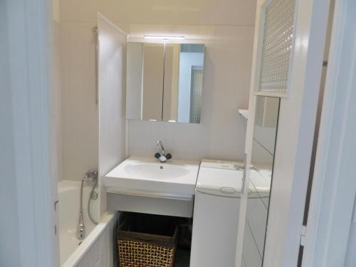 ein weißes Badezimmer mit einem Waschbecken und einem Spiegel in der Unterkunft Atlantique 2, Carnac in Carnac