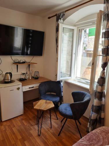 斯普利特的住宿－Inchy Accommodation，厨房配有两把椅子、书桌和窗户