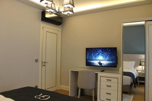 a bedroom with a bed and a desk with a television at Garlon Residence in Istanbul
