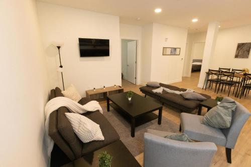 a living room with two couches and a table at Stylish luxe apartment close to New york city in Union City