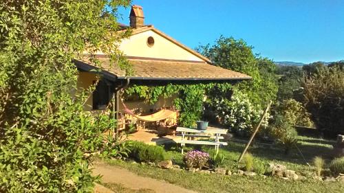 a house with a gazebo with a swing at Il Mandorlino Pitigliano appartamento in tipico casale maremmano con portico e giardino in Pitigliano